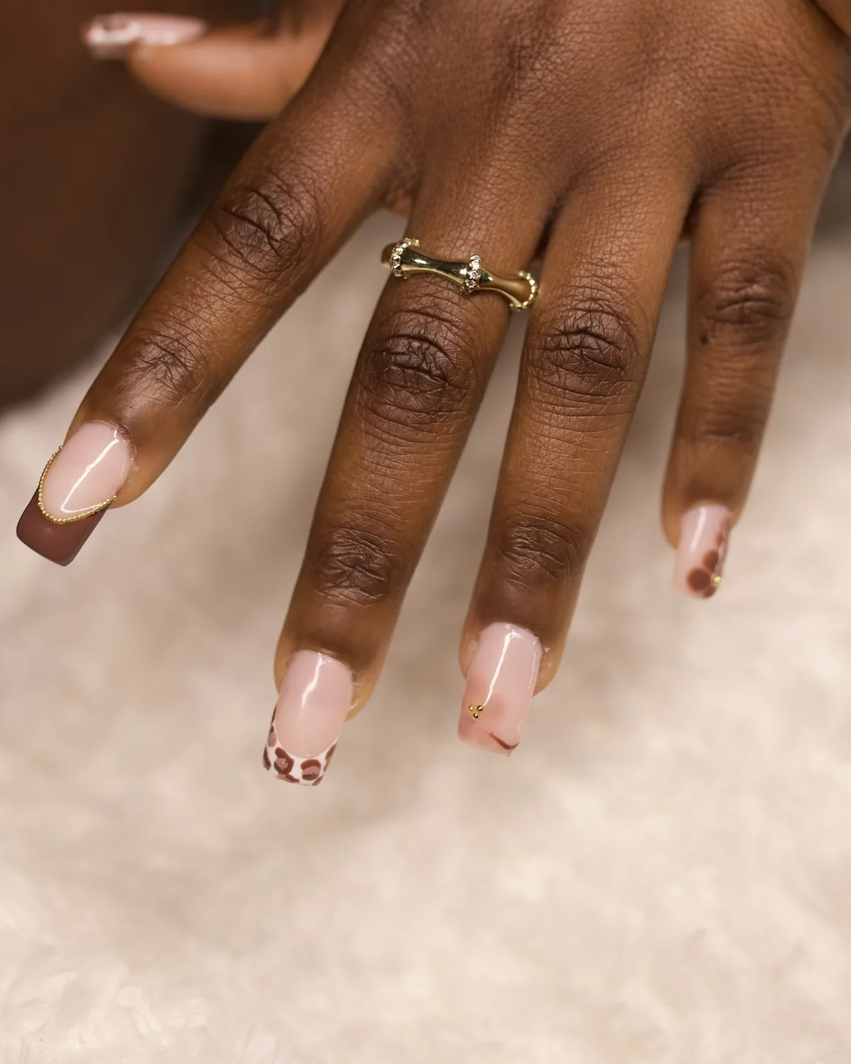 Nail art carré French chocolat motif léopard bijoux dorées.